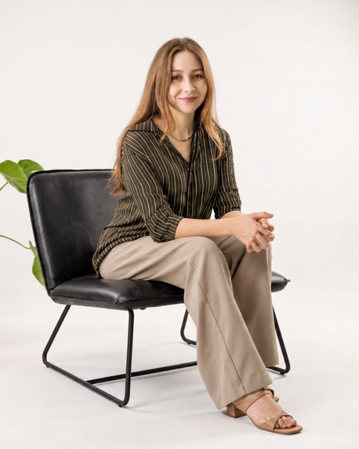Karina Zavala sentada en un sillón de piel negra, sonriendo a cámara